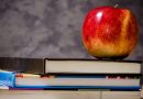 Купчина книги с червена ябълка отгоре