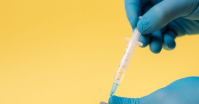 Ръце в медицински ръкавици пълнят спринцовка с ваксина
