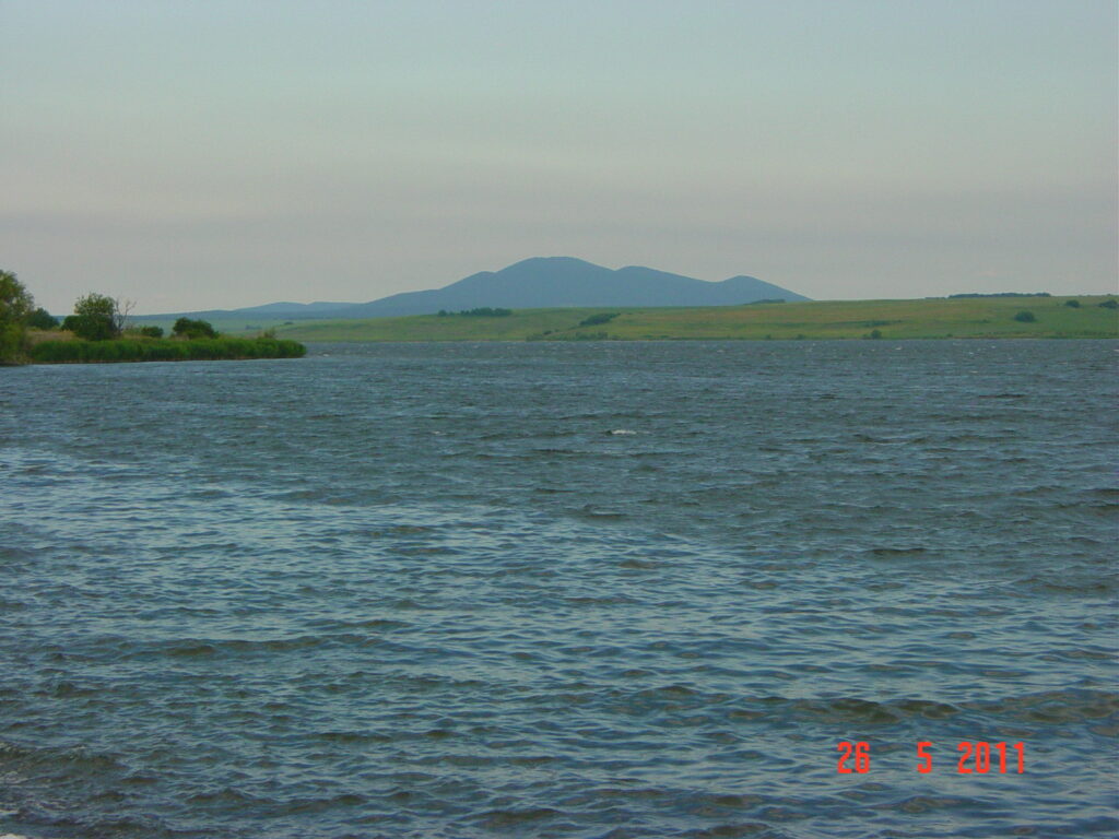 Водите на язовир „Овчарица“ с хълмове на хоризонта
